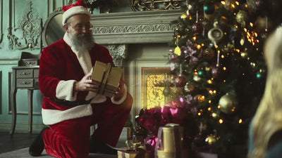 a santa claus packing christmas gifts containing ornaments containing rosaries from holy land 